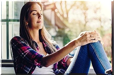 woman meditating in front of a window