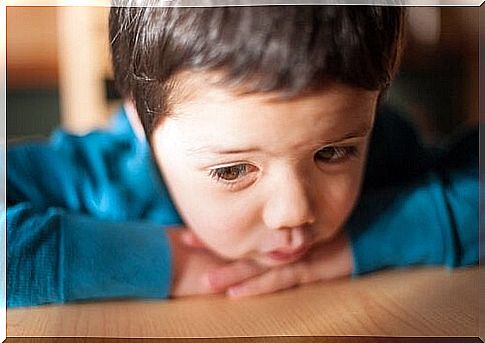 little boy leaning on the table