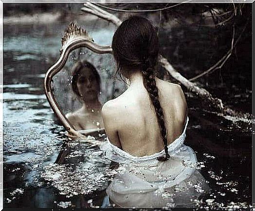 the girl in the water looks at herself in the mirror