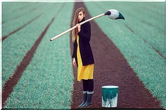 a woman paints the lawn green